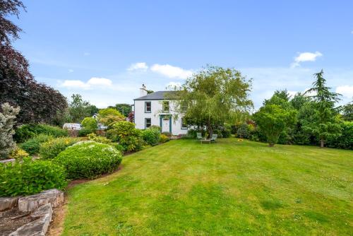 a white house with a large yard with grass at Rosebank House - 12 Guests, 6 Ensuite Bedrooms, EV point, Games Rooms, Wood Burner, Pet Friendly! in Blairgowrie