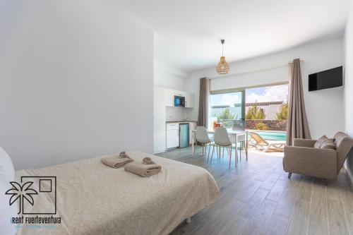 Un dormitorio con una cama y una sala de estar. en Lola Loft 1 Lajares iRent Fuerteventura, en La Oliva