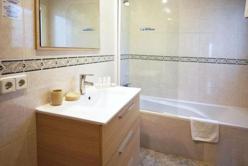 a bathroom with a sink and a shower and a tub at Residencial Bogamarí in San Antonio Bay