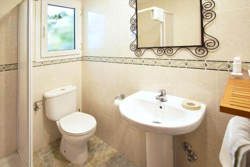 a bathroom with a toilet and a sink and a mirror at Residencial Bogamarí in San Antonio Bay