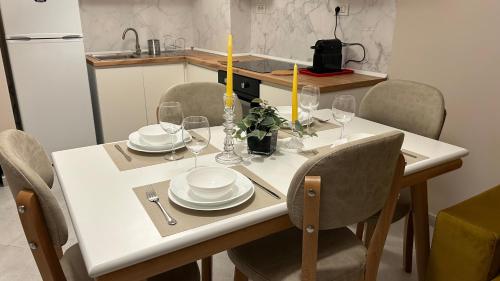 a dining room table with plates and glasses on it at Water Lily Apartments in Vlorë