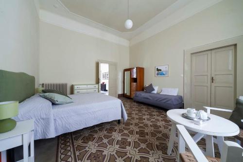 1 dormitorio con 1 cama, 1 mesa, 1 cama y 1 sofá en B&B del Corso, en Ascoli Piceno