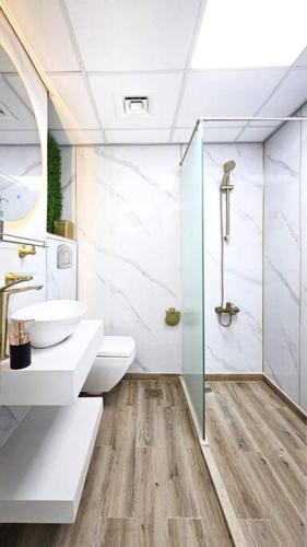 a bathroom with a toilet and a sink and a shower at Luxury Beach Studio in Ras al Khaimah
