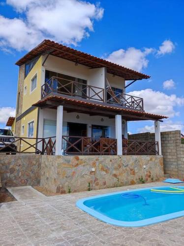 ein Haus mit einem Swimmingpool vor dem Haus in der Unterkunft Refúgio da Serra Gameleiras in Monte das Gameleiras