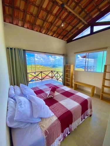 ein Schlafzimmer mit einem Bett in einem Zimmer mit Fenstern in der Unterkunft Refúgio da Serra Gameleiras in Monte das Gameleiras