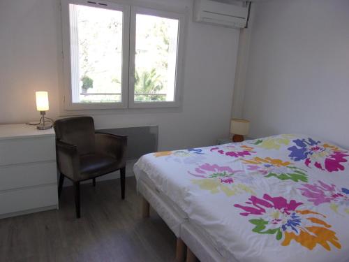 une chambre avec un lit, une chaise et une fenêtre dans l'établissement Confort et lumière, à Sanary-sur-Mer
