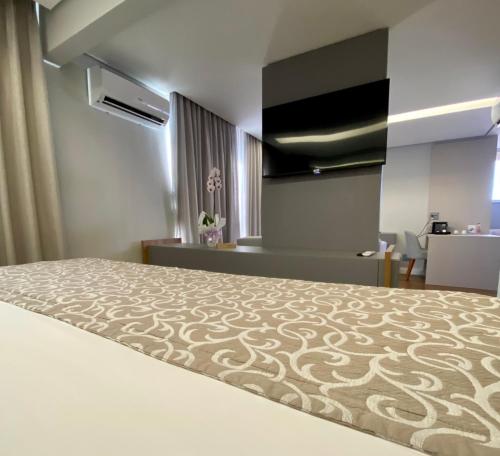 a hotel room with a bed and a desk at H2 Platinum Lourdes in Belo Horizonte