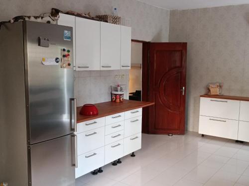 a kitchen with a stainless steel refrigerator and white cabinets at Berlin in Ziguinchor