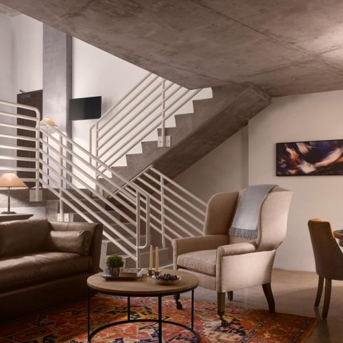 a living room with a couch and a staircase at Plaza la Reina in Los Angeles