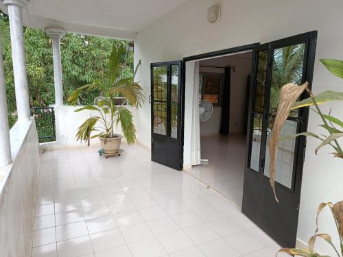 an open door of a house with a plant at Berlin in Ziguinchor