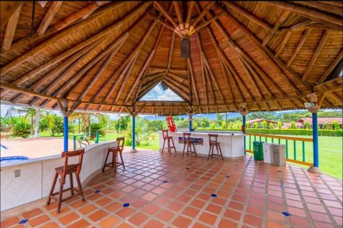a large pavilion with a table and chairs in it at Finca Hotel El Ocaso in Quimbaya