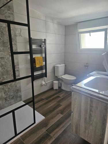 a bathroom with a tub and a toilet and a sink at Le Rubiz in La Coucourde