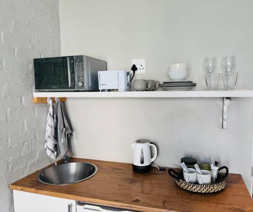 a kitchen counter with a sink and a microwave at Studio #2 in East London