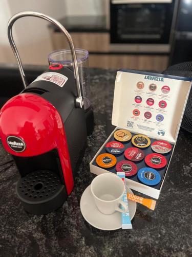 a red coffee maker next to a cup of coffee at Casa Tres A in Vlorë