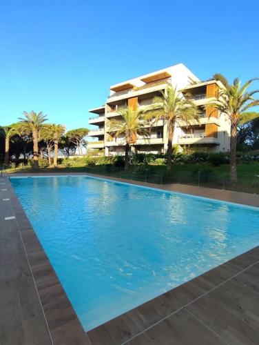 een groot blauw zwembad voor een gebouw bij Appartement neuf Piscine in Fréjus