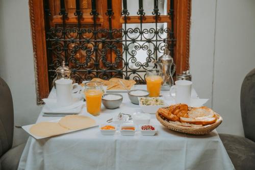 a table with breakfast foods and orange juice on it at Riad Djebel in Marrakech