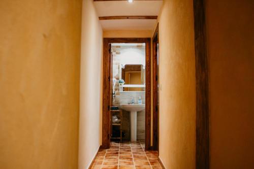 a hallway leading to a bathroom with a sink at Apartamentos El Callejón in Riópar