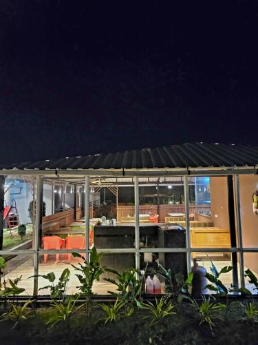 a pavilion with a table and chairs at night at Vayu Resort - Kas Pathar in Kanera