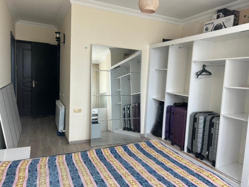 a walk in closet with white shelves and a mirror at Kobuleti Family apartment in K'obulet'i