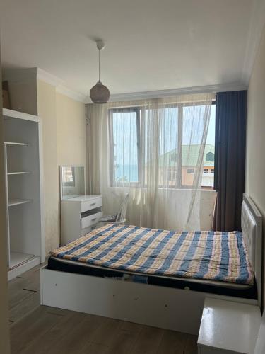 a bedroom with a large bed with a window at Kobuleti Family apartment in K'obulet'i