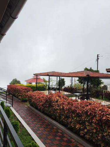 a garden with a brick path and a pavilion at Vayu Resort - Kas Pathar in Kanera