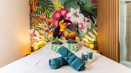 - un lit avec un tas de serviettes dans l'établissement Le Chouette Toucan, à Dijon