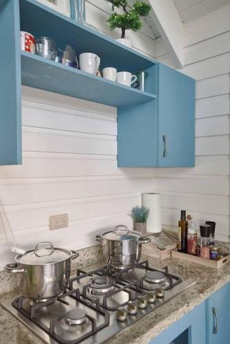 two pots on a stove top in a kitchen at New-CasitaDeLasFlores-View-Wifi-Jacuzzi-Jarabacoa in Jarabacoa