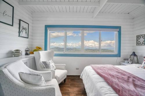 a bedroom with a bed and a chair and a window at New-CasitaDeLasFlores-View-Wifi-Jacuzzi-Jarabacoa in Jarabacoa