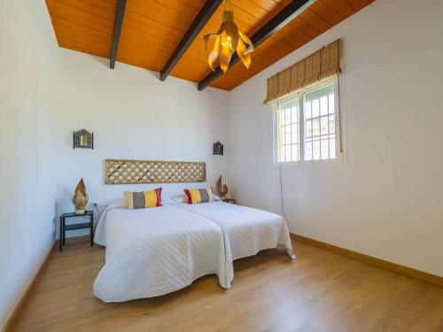a white bedroom with a bed and a window at Cubo's Villa Di Hermosa View in Villafranco de Guadalhorce