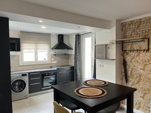 - une cuisine avec une table noire et une cuisinière dans l'établissement Petite maison centre ville, à Chartres
