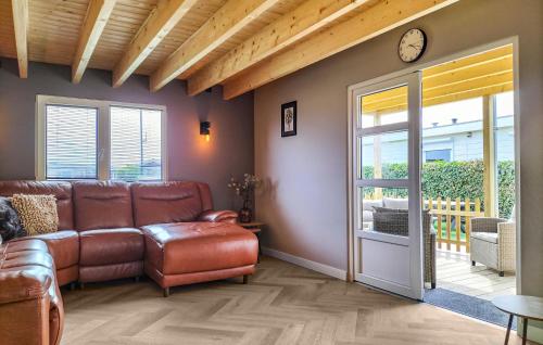 un salon avec un canapé et une horloge au mur dans l'établissement 2 Bedroom Beautiful Home In Stavenisse, à Stavenisse