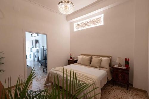 a white bedroom with a bed and a window at Casa EleMar in Barletta