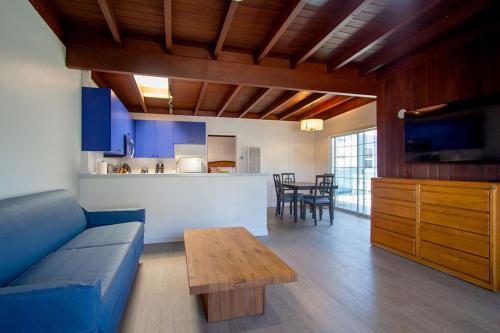 a living room with a blue couch and a table at Edgewater Beach Inn in Santa Cruz
