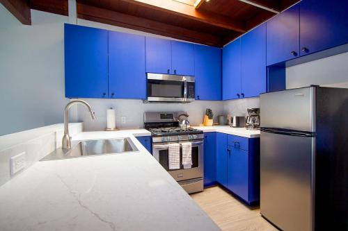 a kitchen with blue cabinets and a stainless steel refrigerator at Edgewater Beach Inn in Santa Cruz