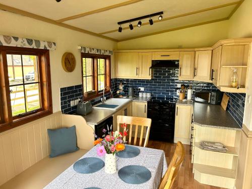 a kitchen with a table with a vase of flowers on it at Barons Granary, The Chicken Run, Iden near Rye in Iden