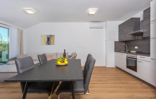 une cuisine et une salle à manger avec une table et des chaises noires dans l'établissement Nice Apartment In Malinska With Wifi, à Malinska