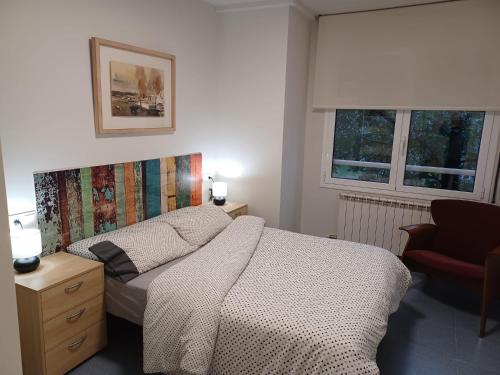 1 dormitorio con 1 cama, 1 silla y 2 ventanas en Apartament Especial Vic, en Vic