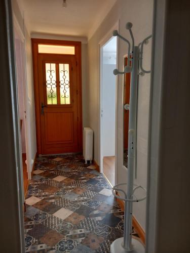 un couloir avec une porte et un sol carrelé dans l'établissement Douceur Vendéenne, à La Roche-sur-Yon