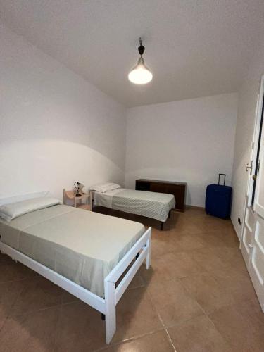 a bedroom with two beds and a blue suitcase at Villa Immacolata in Monteroni di Lecce
