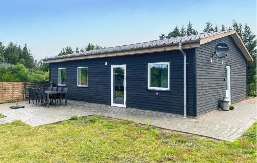 a blue house with a table and a patio at 3 Bedroom Nice Home In Skjern in Skjern
