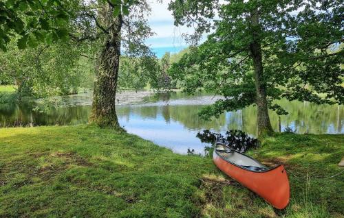 a boat sitting on the grass next to a lake at 1 Bedroom Awesome Home In Västerlanda in Västerlanda