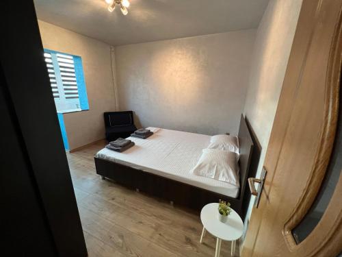 a small bedroom with a bed and a table at Miva Apartments in Mangalia