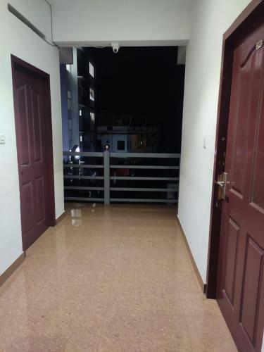 an empty room with two doors and a balcony at Vidhara Rooms in Trivandrum