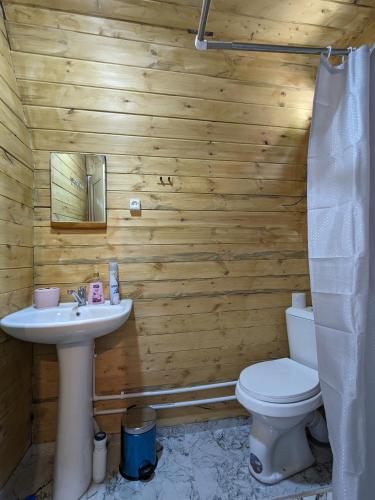 a wooden bathroom with a sink and a toilet at Guest House in Zhabeshi Lali in Zhabeshi