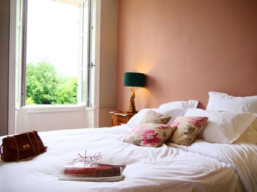 a bedroom with a white bed with a window at Domaine du cloitre in Pléneuf-Val-André