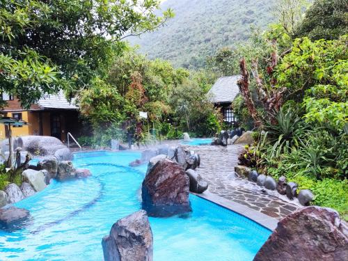 a pool in a resort with rocks in the water at Termas de Papallacta in Papallacta