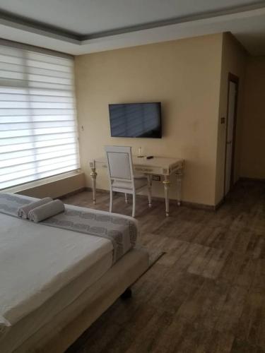 a bedroom with a desk and a bed and a chair at Ellyxville Hotel in Lekki