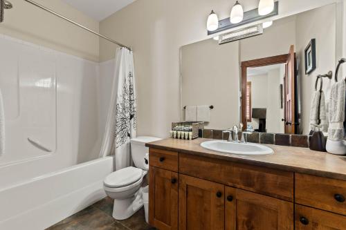 a bathroom with a sink and a toilet and a tub at Settler's Crossing #56 ski-in ski-out condo with private hot tub in Sun Peaks