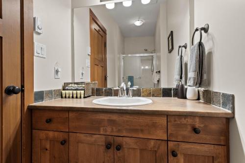 a bathroom with a sink and a mirror at Settler's Crossing #56 ski-in ski-out condo with private hot tub in Sun Peaks