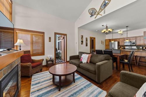 a living room with a couch and a table at Settler's Crossing #56 ski-in ski-out condo with private hot tub in Sun Peaks